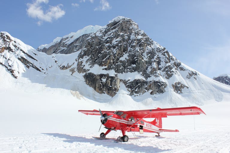 Vibrant red plane on the snowy terrain of Denali National Park, Alaska.