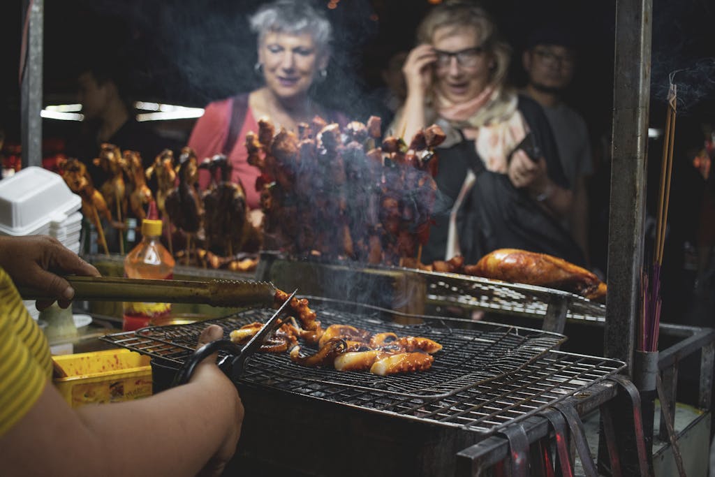 Vibrant street food barbecue scene at Hội An night market, featuring grilled seafood and skewers.