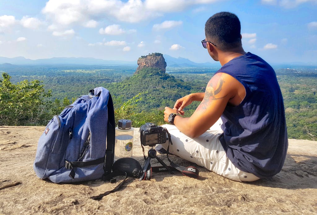 A man enjoys the scenic view of Sigiriya Rock in Sri Lanka, an iconic travel destination.