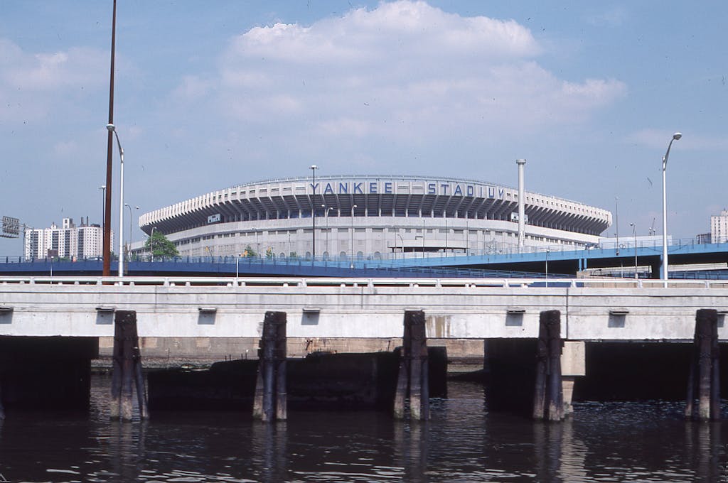 A scenic view of Yankee Stadium visible from a nearby waterfront bridge in New York.