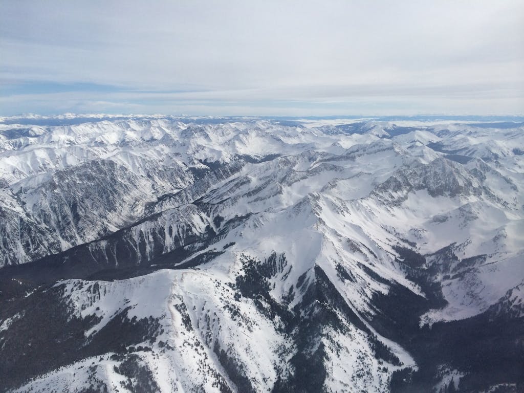 A stunning aerial view of snow-covered Rocky Mountains near Aspen, Colorado.