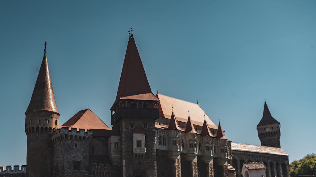 A stunning view of a historical castle with iconic towers under a clear blue sky.