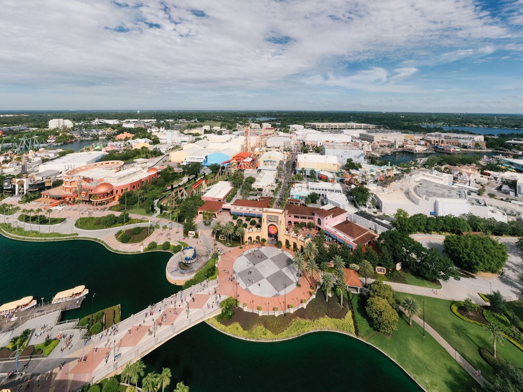 Aerial shot showcasing the vibrant theme park layout of Universal Studios Orlando with lush greenery and blue skies.