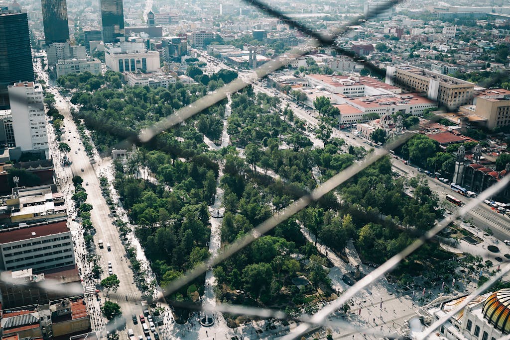 Aerial view of a vibrant park in Mexico City surrounded by skyscrapers and urban landscape.