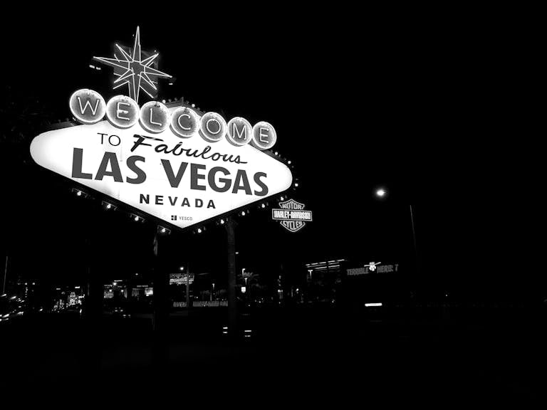 Black and white photo of the famous Las Vegas sign illuminated at night.