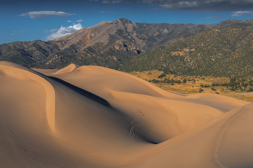 Breathtaking landscape of sand dunes with mountain background in Colorado.