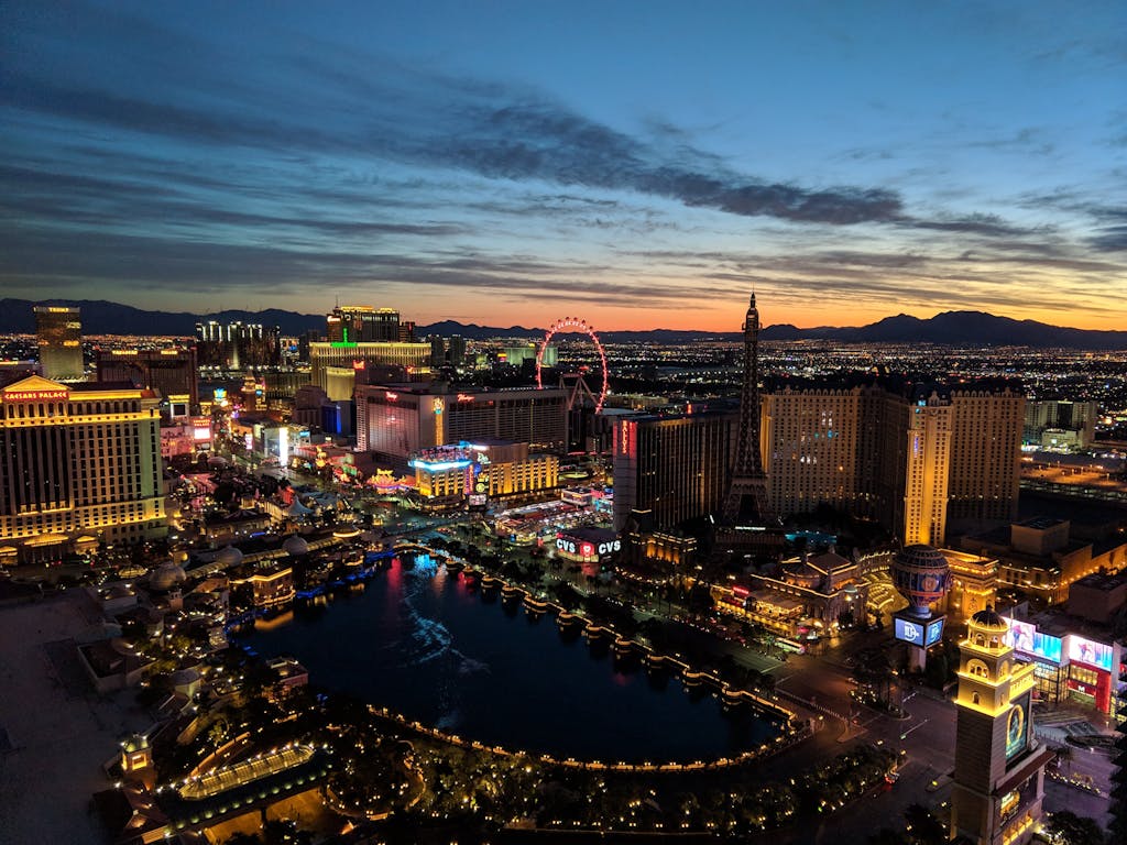 Captivating aerial view of Las Vegas Strip with city lights at dusk and iconic landmarks.