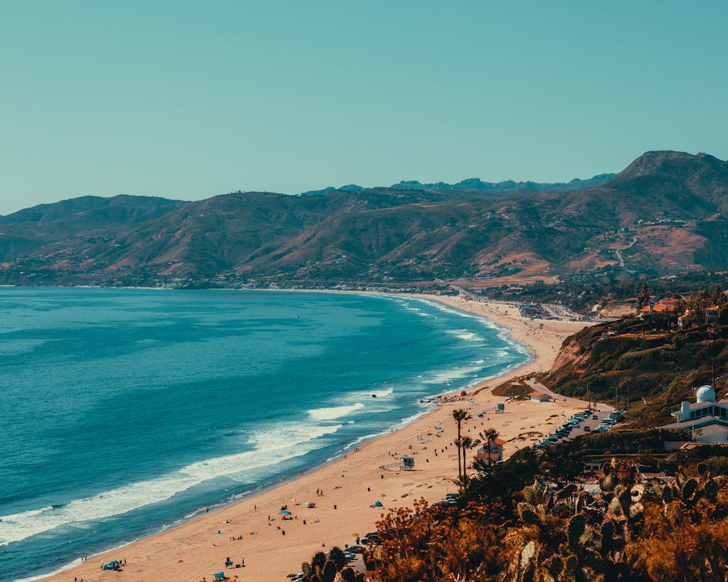 Captivating high angle view of Malibu's coastline, featuring beach, mountains, and ocean.