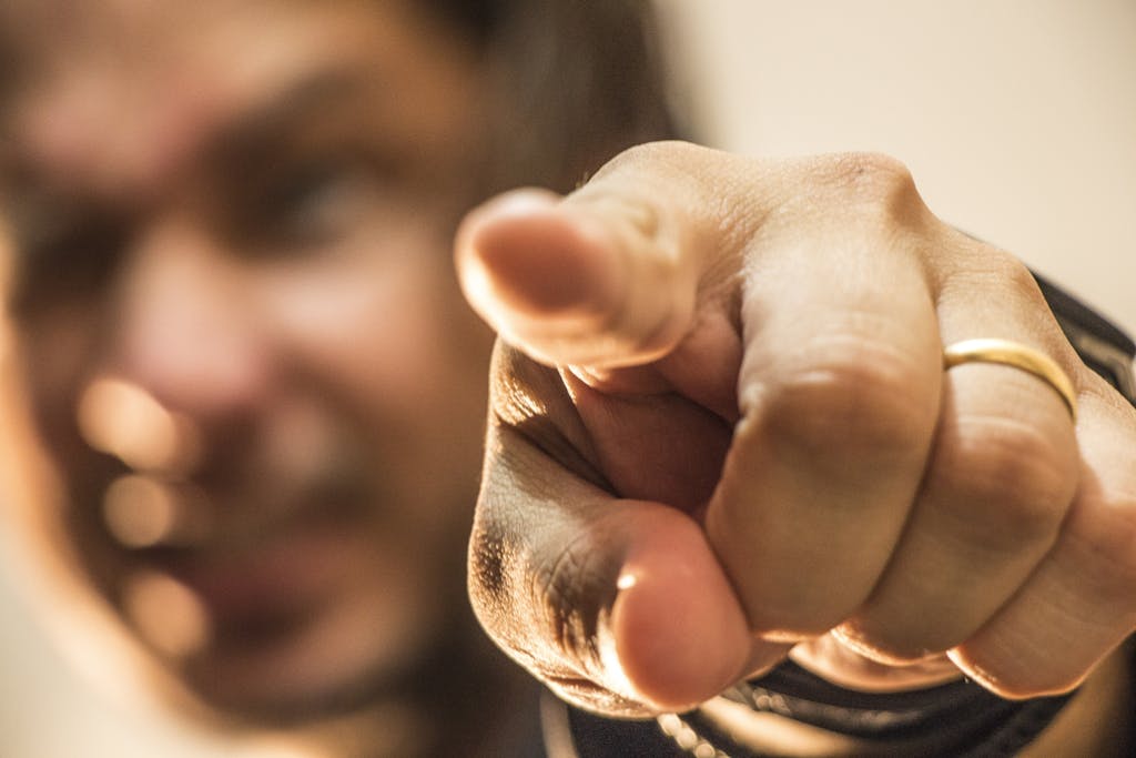 Dynamic close-up of a hand pointing forward with a blurred background.