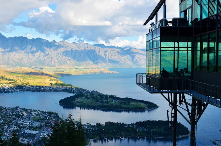 Experience a captivating view of Lake Wakatipu and The Remarkables from the Skyline Restaurant in Queenstown, New Zealand.