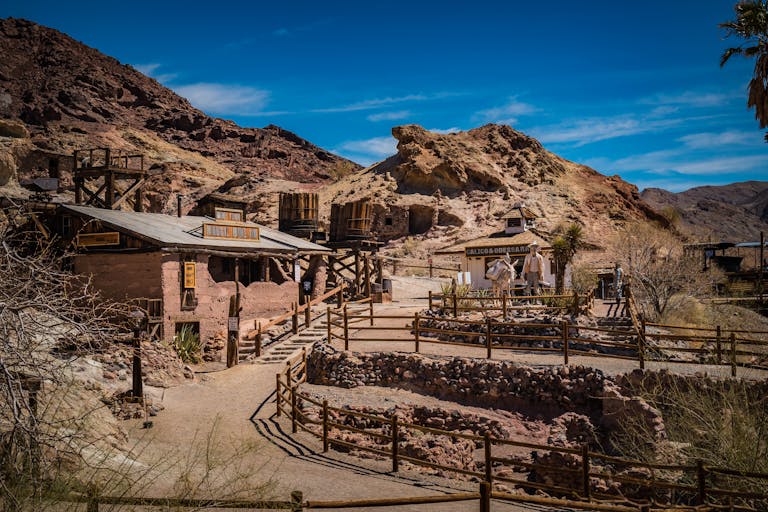 Explore a rustic old west village nestled in a scenic desert setting.