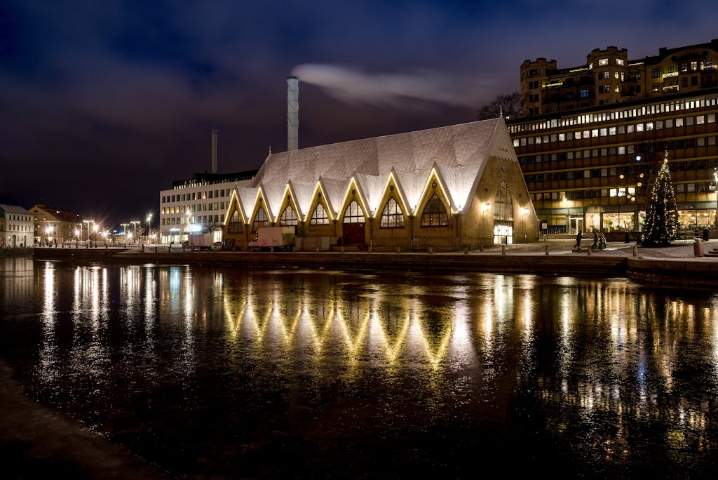 Illuminated fish market hall with reflections in Gothenburg at night.