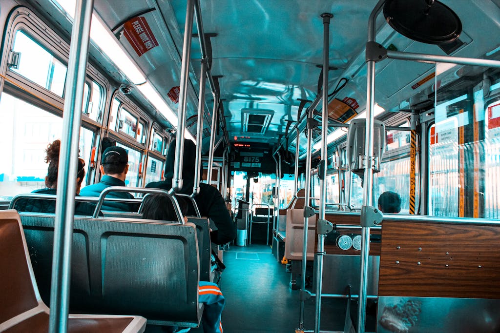 Interior shot of a city bus filled with diverse passengers commuting during the day.