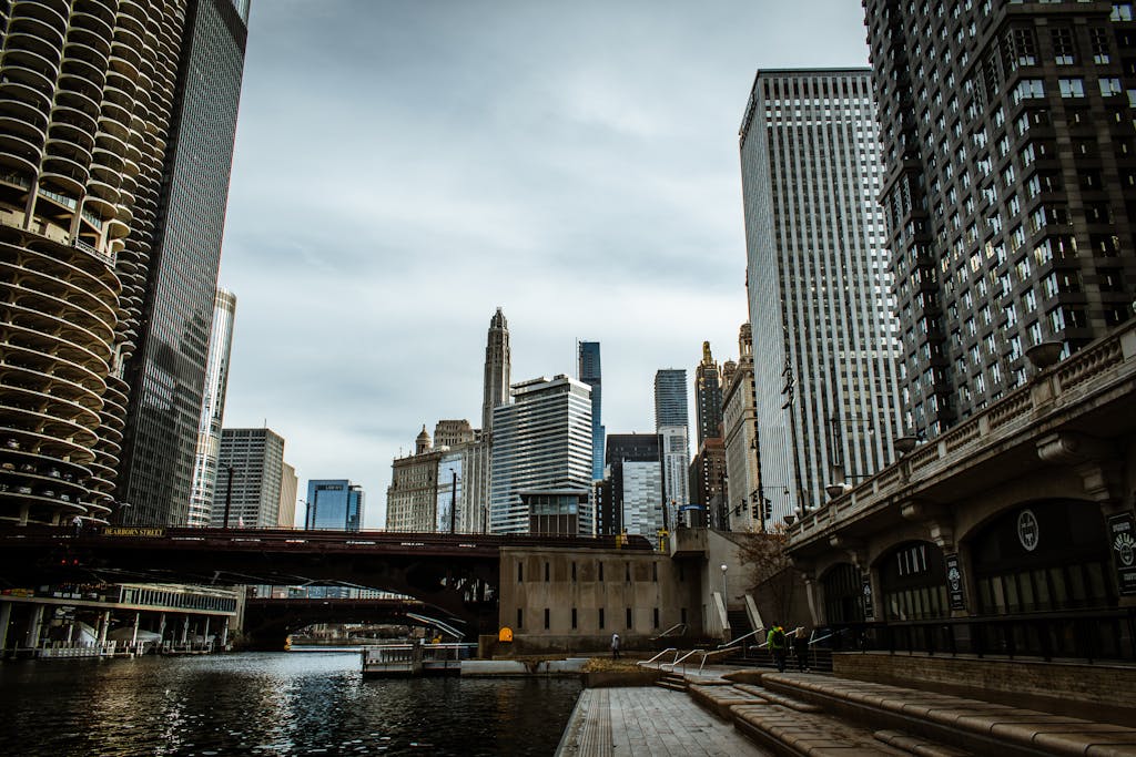 Low angle shot of Chicago's iconic skyscrapers along the riverwalk, showcasing urban architecture.