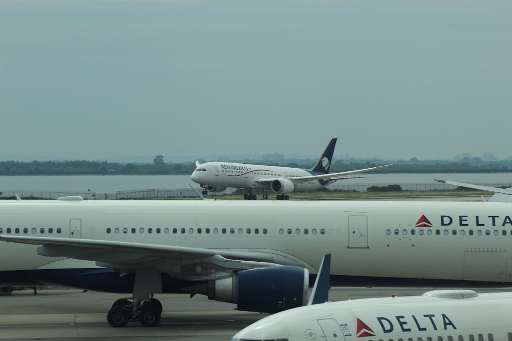 Multiple airplanes from Delta Airlines parked on a runway with a dull sky.