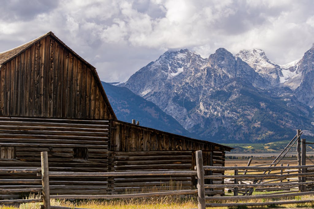 Scenic view of a rustic barn against the Teton Mountains in Wyoming.