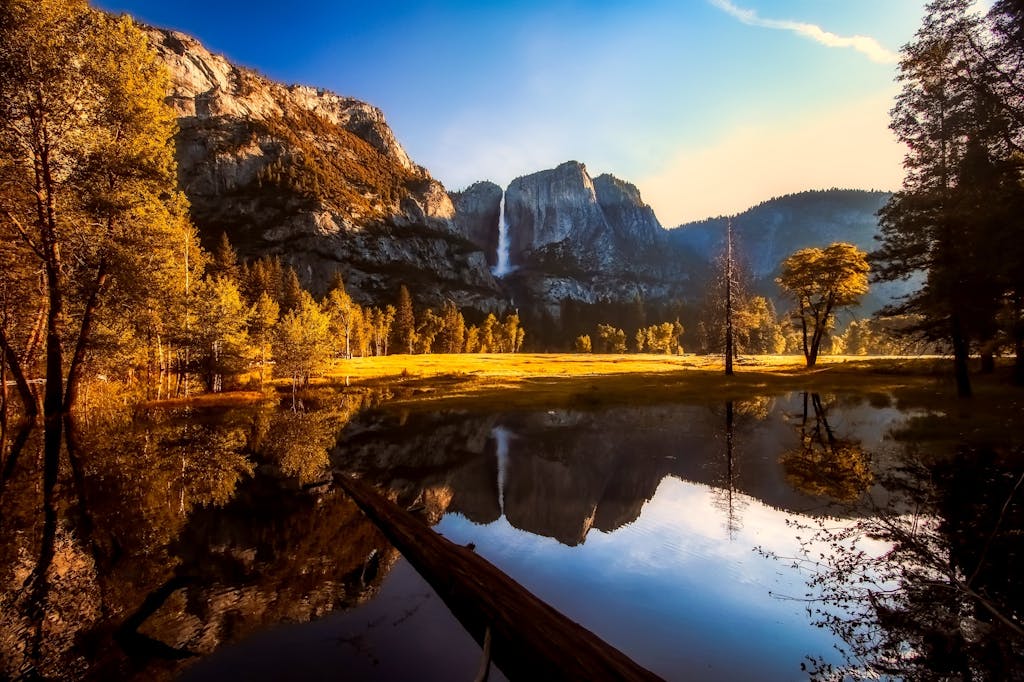 Scenic view of Yosemite National Park showcasing a waterfall and clear reflections in tranquil water.