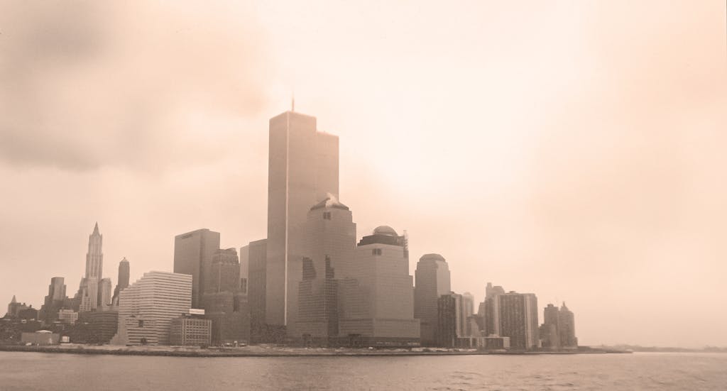 Sepia-toned view of New York City skyline with the Twin Towers on a foggy day.