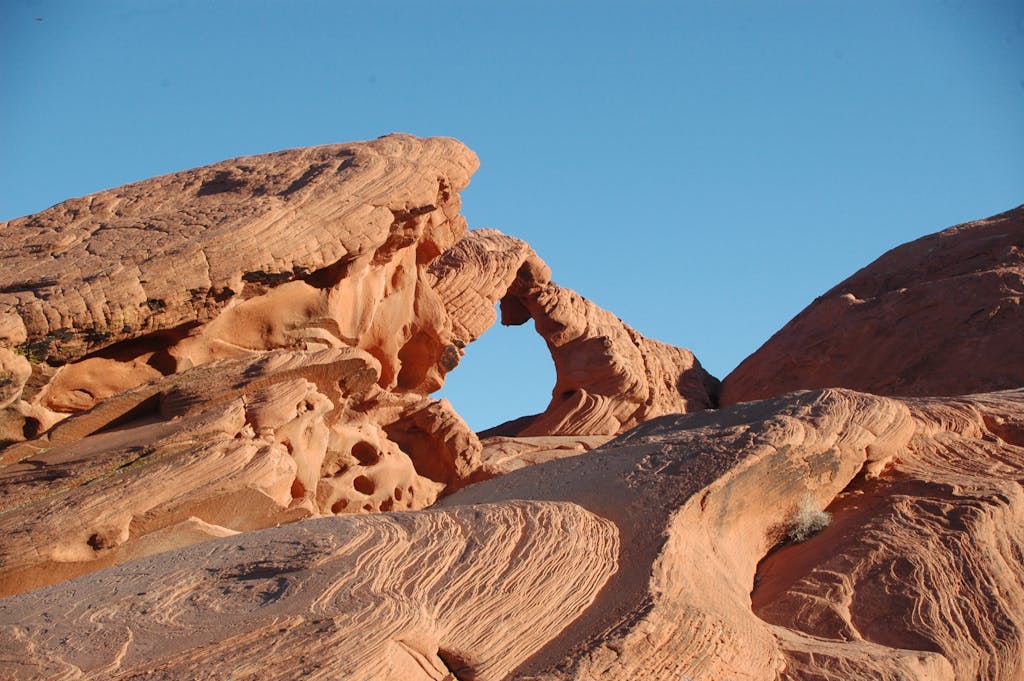 Stunning sandstone arch formation in Valley of Fire State Park, Nevada under clear blue skies.