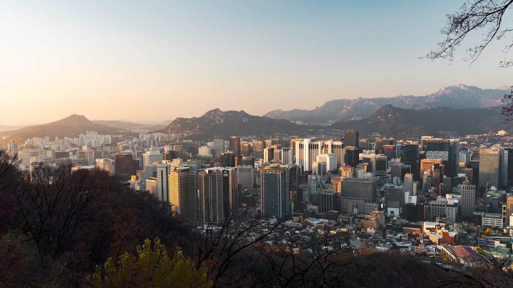 Stunning skyline view of Seoul from above at sunset, featuring Namsan Tower.