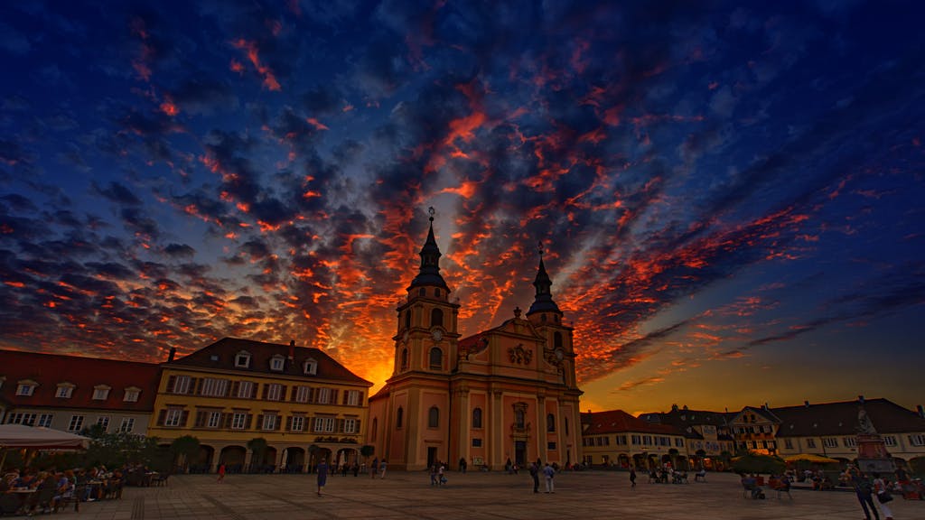 Stunning sunset view of a church in Ludwigsburg, Germany with vibrant cloud formations.