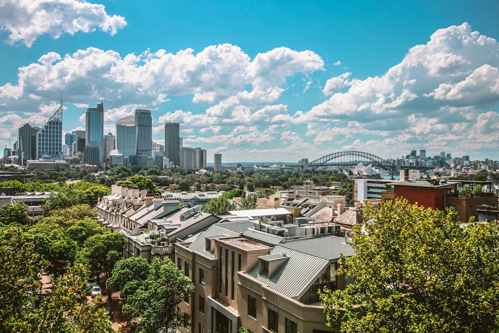 Stunning view of Sydney's skyline featuring the Harbour Bridge and Opera House under a clear blue sky.