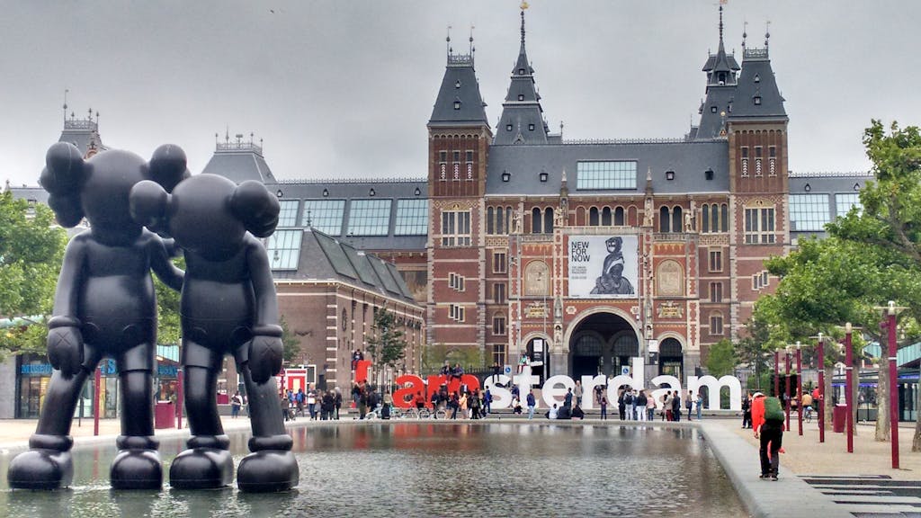 The Rijksmuseum facade with modern art sculptures and reflection in Amsterdam.