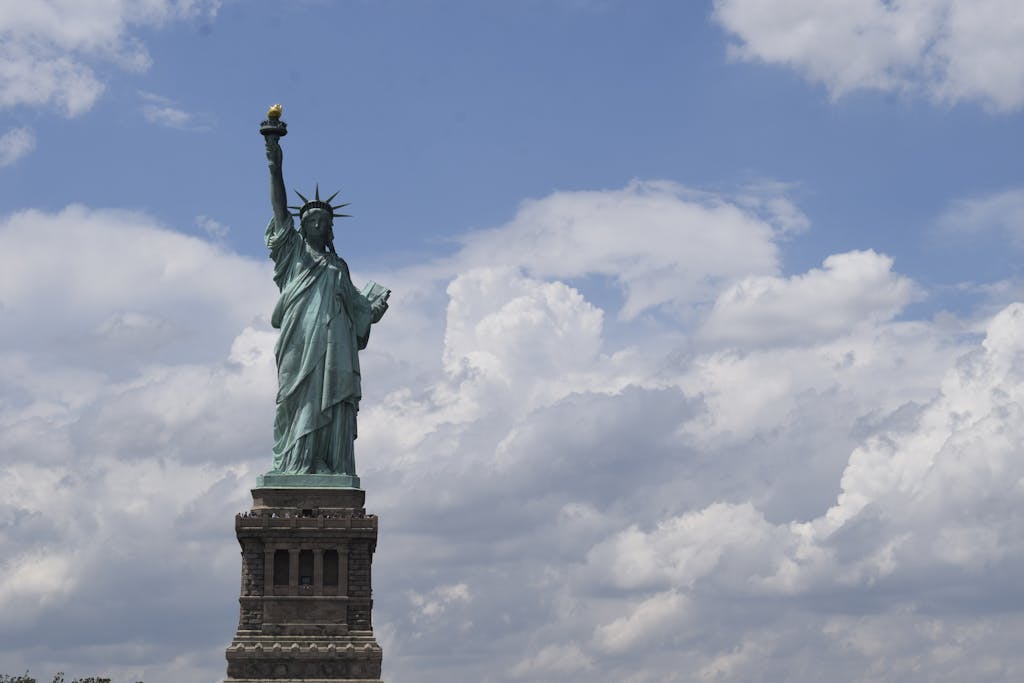 View of the iconic Statue of Liberty with a vibrant blue sky background, symbolizing freedom.