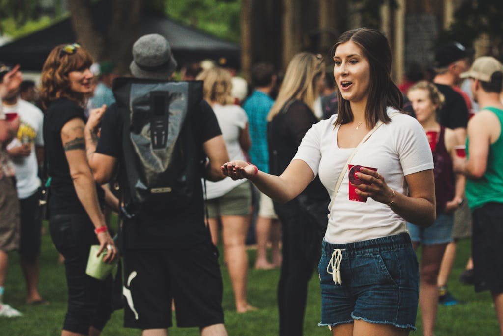 A lively scene at an outdoor festival with people socializing and enjoying beverages.