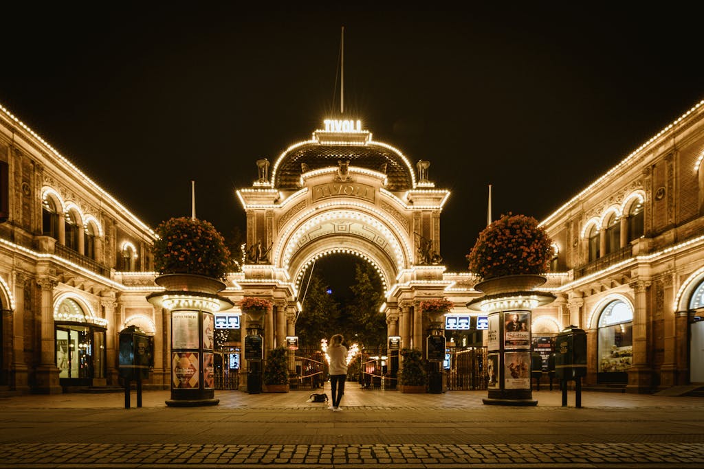 A night view of the brightly lit entrance of Tivoli Gardens in Copenhagen.