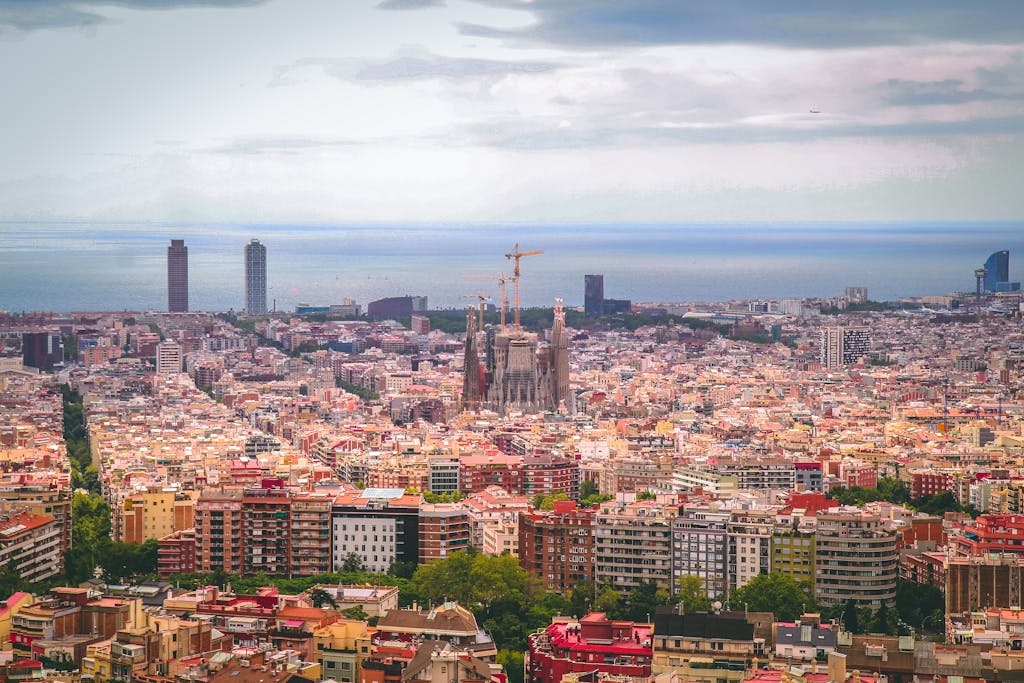 A panoramic view of Barcelona city with Sagrada Familia and coastline in daylight.