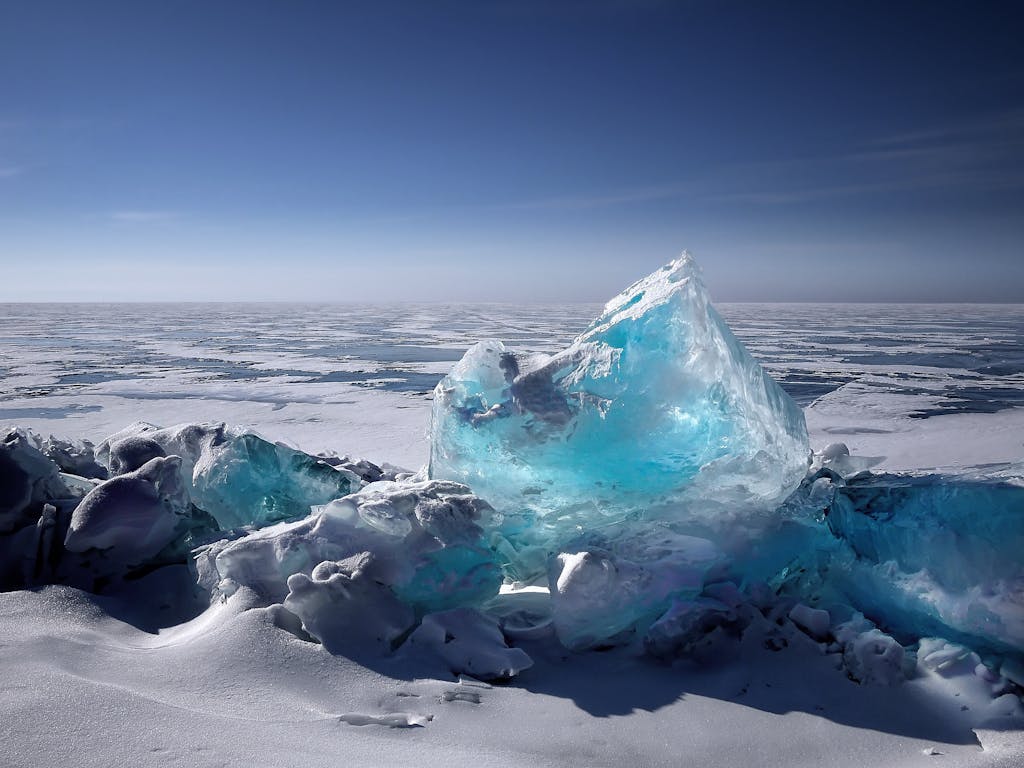 Captivating ice formation on a frozen lake under a bright blue sky during winter.