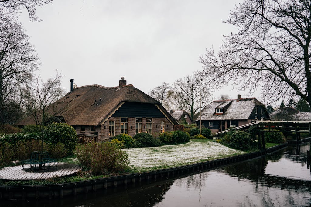 Charming winter view of thatched cottages by the canal in Giethoorn, Netherlands.