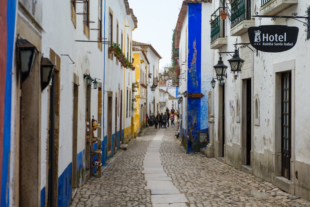 Cobblestone street with colorful houses in a historic Portuguese town.