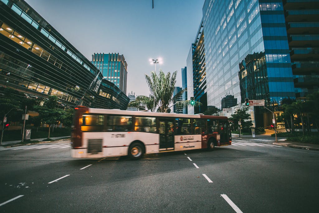 Dynamic city scene featuring a bus in motion amidst modern urban architecture at twilight.