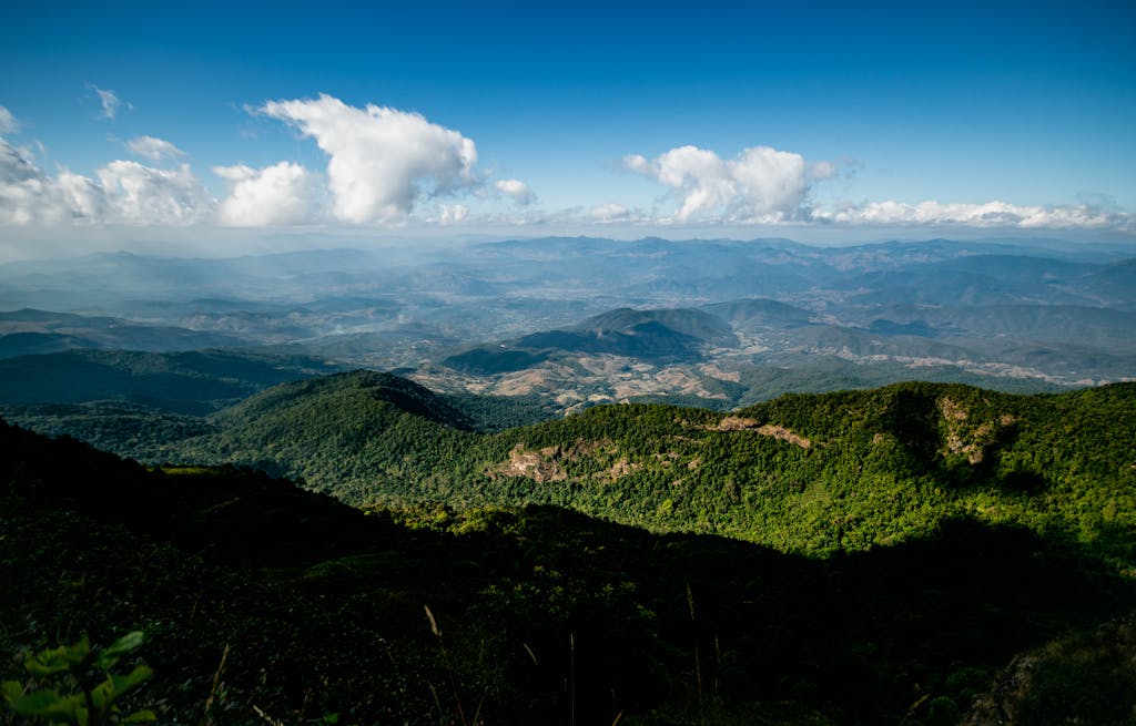 Expansive view of lush green mountains and clouds in Chiang Mai, Thailand.