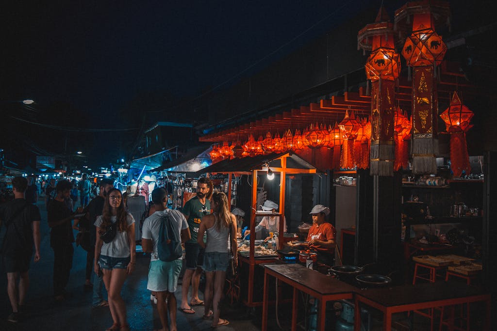 Explore the lively Pai night market bustling with tourists and local vendors under colorful lanterns.