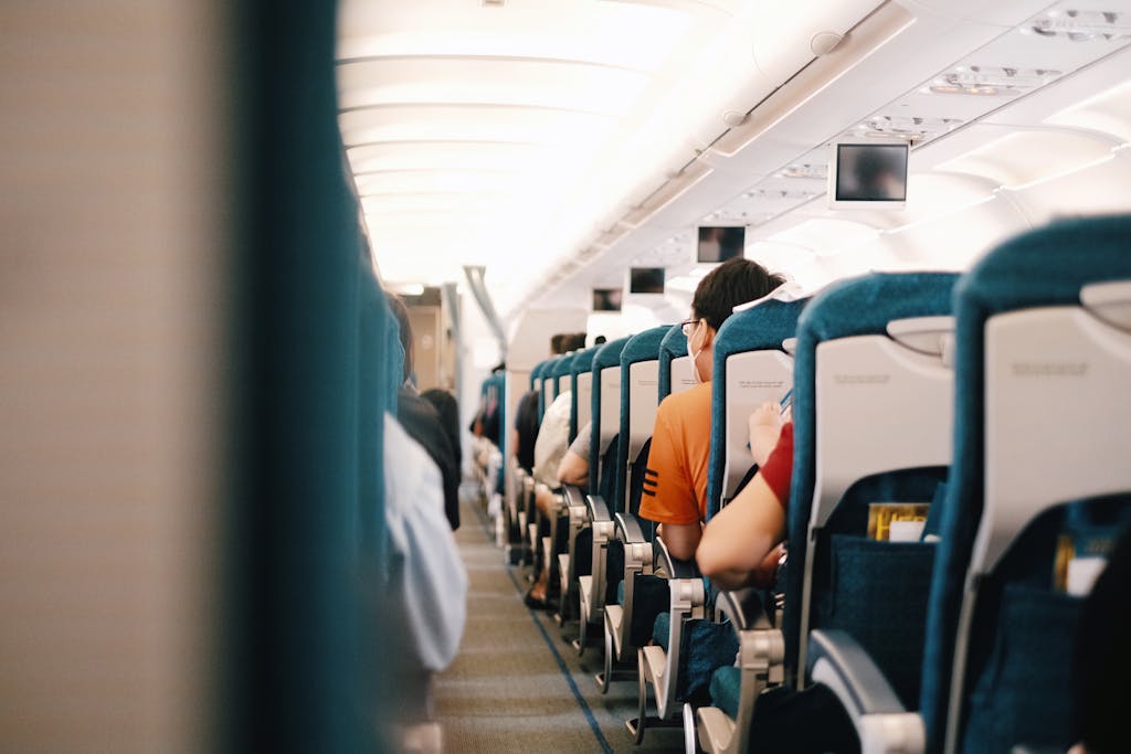 Interior view of airplane cabin showing passengers seated during a flight.