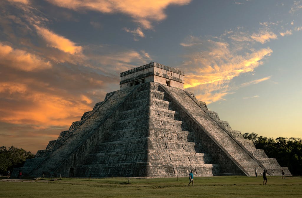 Majestic view of El Castillo pyramid at Chichen Itza with a vibrant sunset sky.