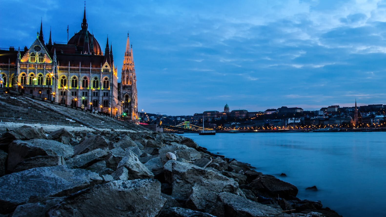 Scenic view of Budapest Parliament and Danube River at dusk.