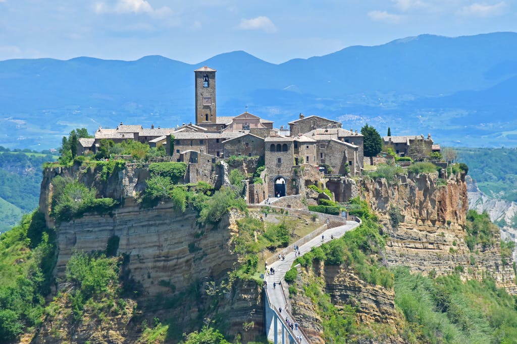 Scenic view of Civita di Bagnoregio perched on a cliff with mountain backdrop.