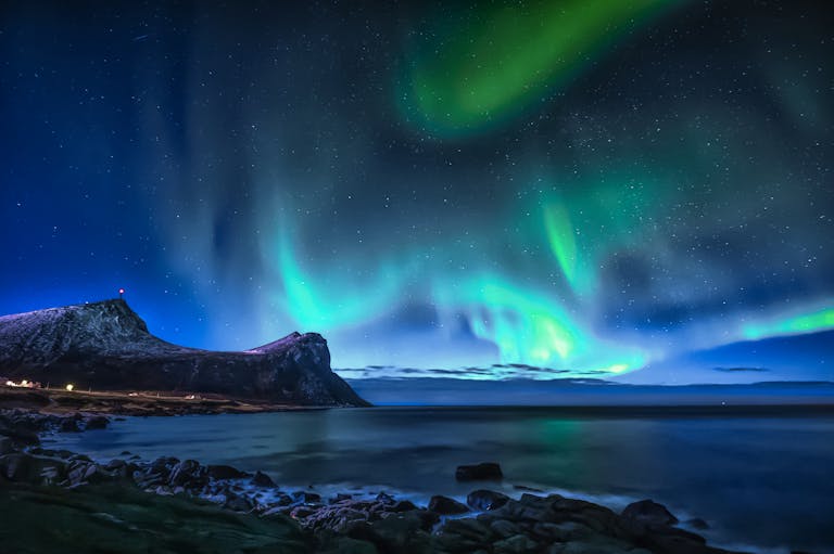 Spectacular northern lights illuminate the night sky over Myrland Fjord, Norway.