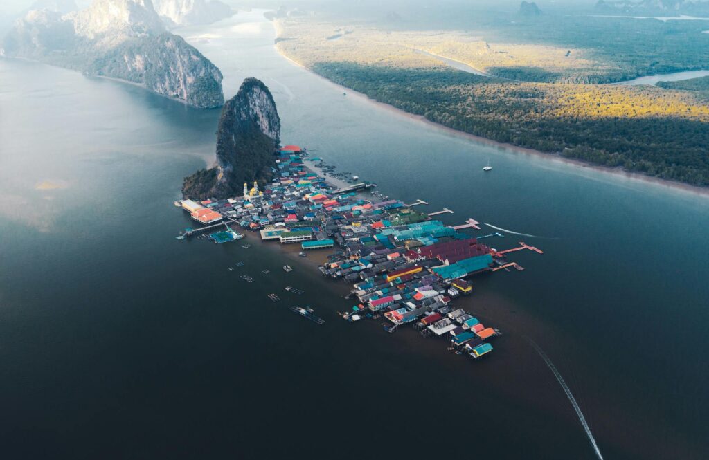 Stunning aerial shot of a vibrant floating village surrounded by calm waters and lush landscape.