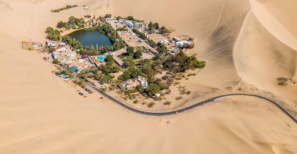 Stunning aerial view of Huacachina oasis surrounded by sand dunes in Ica, Peru.