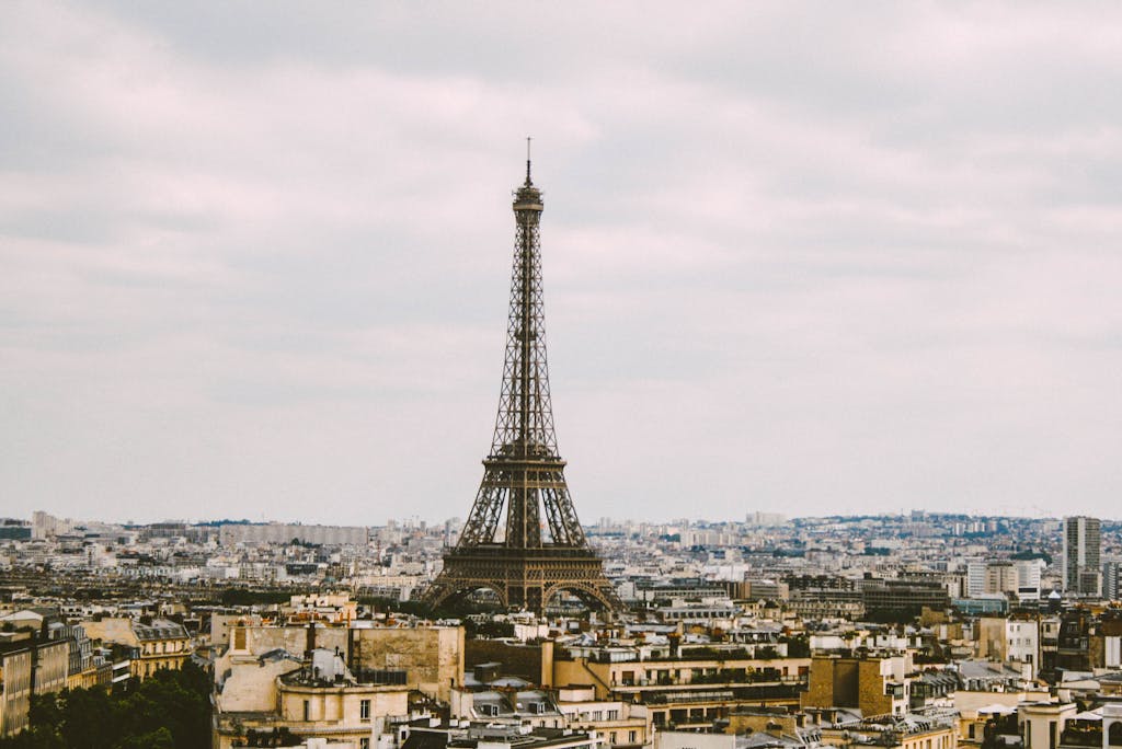 Stunning aerial view of the Eiffel Tower and Parisian cityscape on a cloudy day.