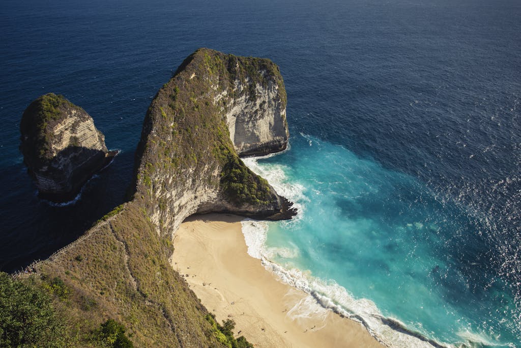 Stunning aerial view of the iconic Kelingking Beach in Bali, showcasing turquoise waters and dramatic cliffs.