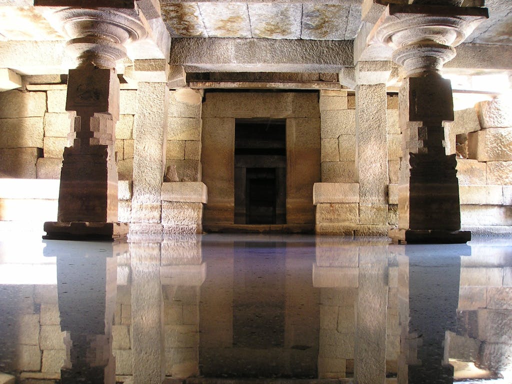 Stunning view of an ancient stone temple interior with water reflections.